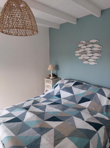 - une chambre avec un lit coloré et une lampe dans l'établissement Maison dans la Manche, à Saint-Malo-de-la-Lande