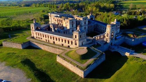 an aerial view of a large building on a field at Dworek pod Krzyżtoporem Ujazd Agroturystyka- pokoje do wynajęcia in Iwaniska