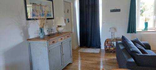 un salon avec un canapé bleu et une table dans l'établissement Maison dans la Manche, à Saint-Malo-de-la-Lande