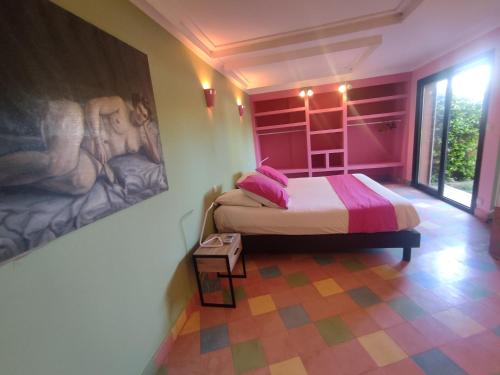 une chambre avec un lit et un tableau au mur dans l'établissement Chambre Rose Opale, Riad 9 Couple only au village naturiste, au Cap d'Agde