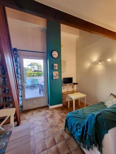 une chambre avec un lit et une horloge au mur dans l'établissement Studio Bord de mer avec terrasse, à Saint-Georges-de-Didonne