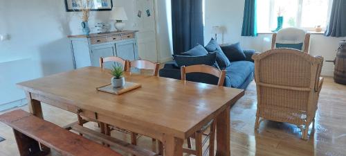 un salon avec une table et des chaises en bois dans l'établissement Maison dans la Manche, à Saint-Malo-de-la-Lande