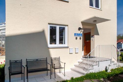 a building with two chairs and a table on a patio at Ferienwohnung Fischerhaus in Wasserburg am Bodensee