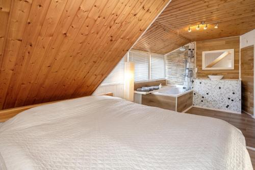 a bedroom with a white bed and a sink at Ferienwohnung Fischerhaus in Wasserburg am Bodensee