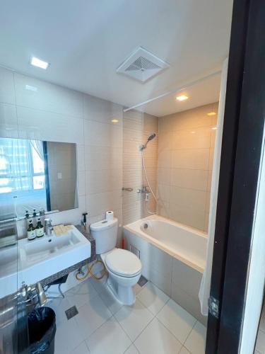 a bathroom with a toilet and a tub and a sink at OPR High- floor Seaview Studio in Lapu Lapu City