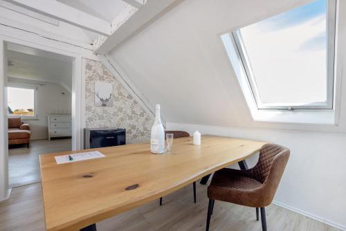 a room with a wooden table with chairs and a window at Ferienwohnung Fischerhaus in Wasserburg am Bodensee