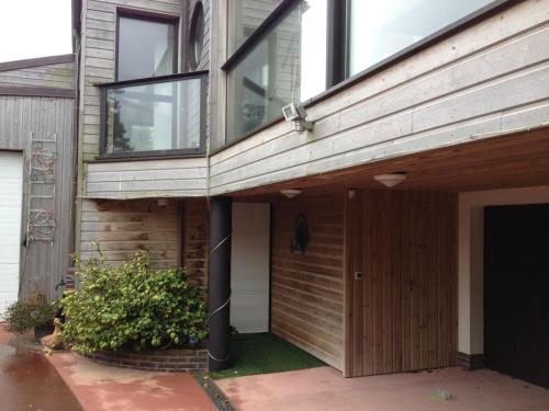 una casa con una puerta de madera y un edificio en Les Jardins d'Omaha, en Saint-Laurent-sur-Mer