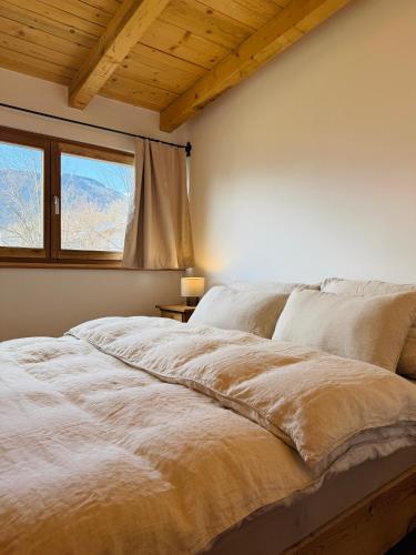 a bedroom with a white bed with a window at GASSERHOF Dölsach in Dölsach