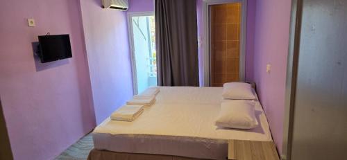 a bedroom with purple walls and a bed with pillows at Masal Hotel in Cesme