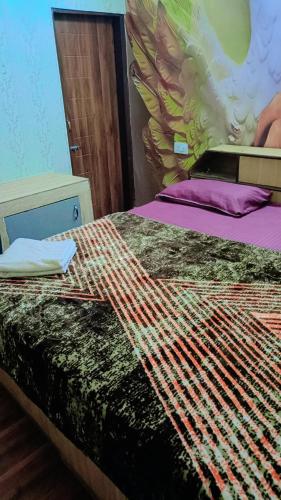 a bed with a colorful comforter on top of it at Hotel paris in Mohali