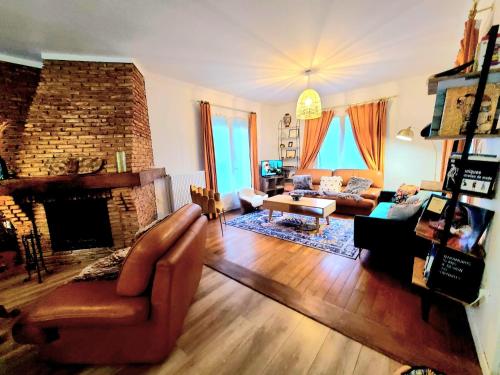 a living room with a couch and a fireplace at PEACE & PINK Maison zen & Cocon stylé a 5 mn des vagues de Wimereux in Maninghen-Henne