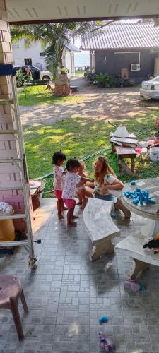 three little girls playing on a bench in a yard at Baan rabianglay 2 in Ban Hin Sam Kon
