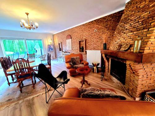 a living room with a brick wall and a fireplace at PEACE & PINK Maison zen & Cocon stylé a 5 mn des vagues de Wimereux in Maninghen-Henne