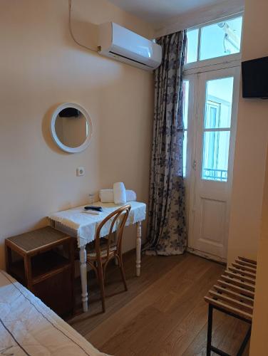 a room with a table with chairs and a window at Anesis Hotel in Loutra Edipsou