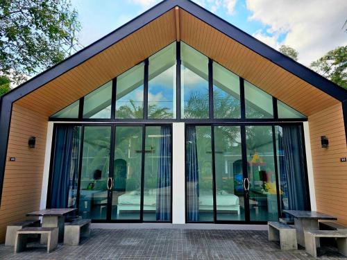 a glass building with two benches in front of it at Saithong Resort in Pak Meng