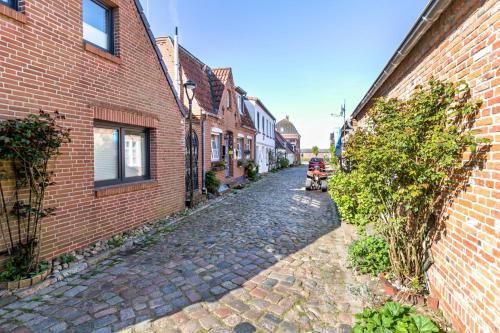 a cobblestone street in an alley between buildings at Lüddes Fischerhuus in Husum