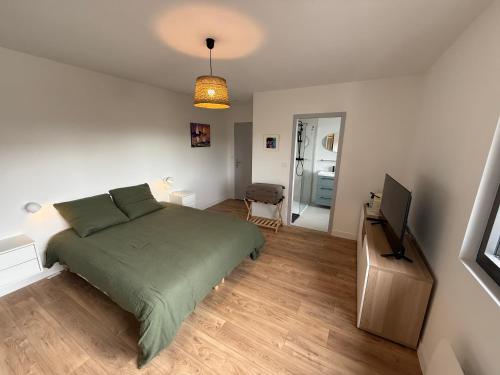a bedroom with a bed and a flat screen tv at La Parenthèse du golfe chambre d hôte in Arradon