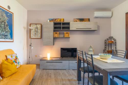 a living room with a couch and a table with a television at Tilly by DomusAway in Olbia