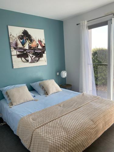 a bedroom with a bed with blue walls and a window at Ama Lur in Hasparren