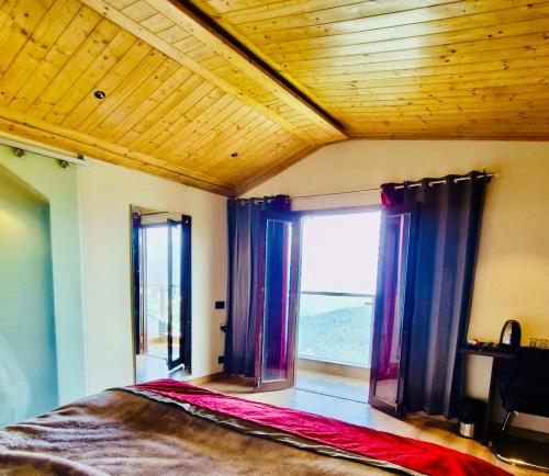 a bedroom with a bed with windows and a wooden ceiling at Yarrows, Narkanda, A boutique stay in Nārkanda