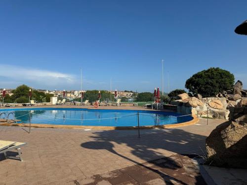 a large swimming pool in a park at Bilocale Residence Capo D'Orso, Palau in Palau
