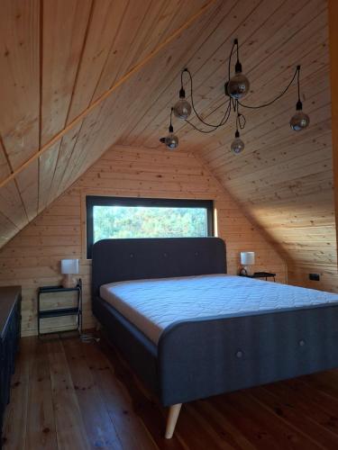 a bedroom with a bed in a wooden room at Domek w Sośninie, stodoła Dzierżenin in Dzierzenin