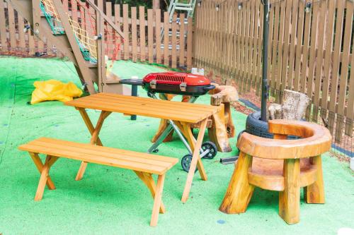 a picnic table and two benches and a grill at 小路裏園 Kojiuraen in Kannami