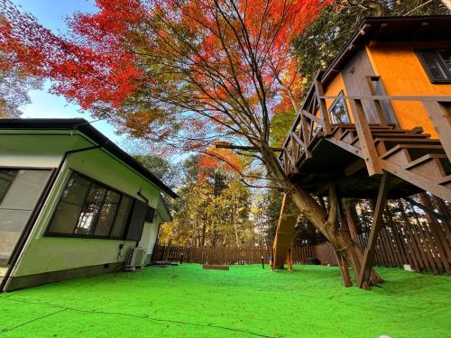 a house with a tree next to a building at 小路裏園 Kojiuraen in Kannami