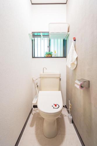 a bathroom with a white toilet with a window at 小路裏園 Kojiuraen in Kannami