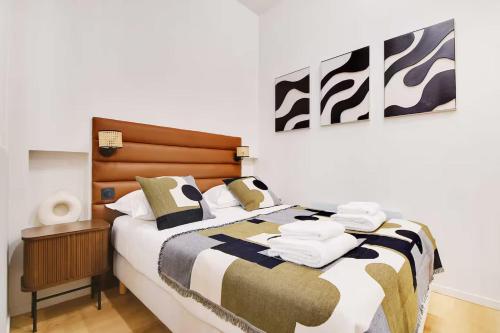 une chambre avec un lit avec une tête de lit en bois dans l'établissement Les Halles - Grands Boulevards Stylish 2BR - 6P, à Paris