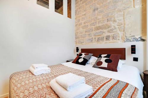 une chambre avec un lit avec des serviettes dessus dans l'établissement Les Halles - Grands Boulevards Stylish 2BR - 6P, à Paris