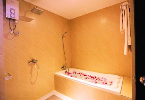 a bathroom with a shower and a tub with sprinkles at Angkor Home 27 in Phumĭ Réach Born
