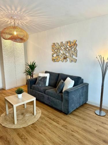 un salon avec un canapé bleu et une table dans l'établissement studio situé proche de la plage, à La Grande Motte