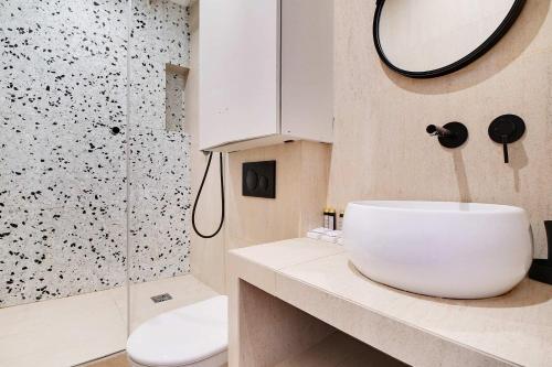 une salle de bain avec un lavabo blanc et une douche dans l'établissement Les Halles - Grands Boulevards Cozy 1BR - 4P, à Paris