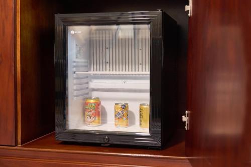 an open refrigerator with cans of food in it at Wyndham Grand Plaza Royale Chenzhou in Chenzhou