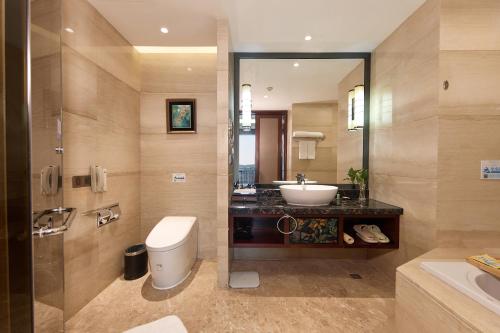 a bathroom with a sink and a toilet and a mirror at Wyndham Grand Plaza Royale Chenzhou in Chenzhou