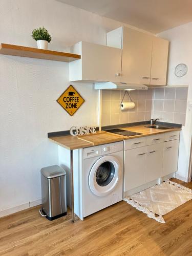 une cuisine avec un lave-linge et un panneau dans l'établissement studio situé proche de la plage, à La Grande Motte