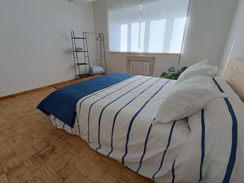 a bedroom with a large bed with blue and white sheets at A Torre in Ribadeo