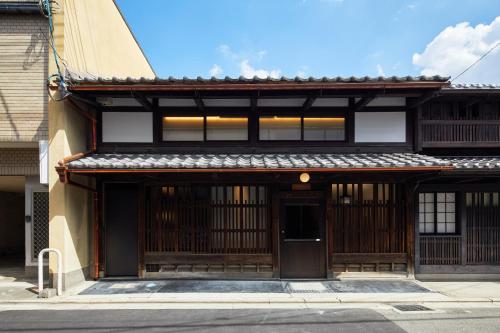 an asian building with a door in a street at Enso Machiya in Kyoto