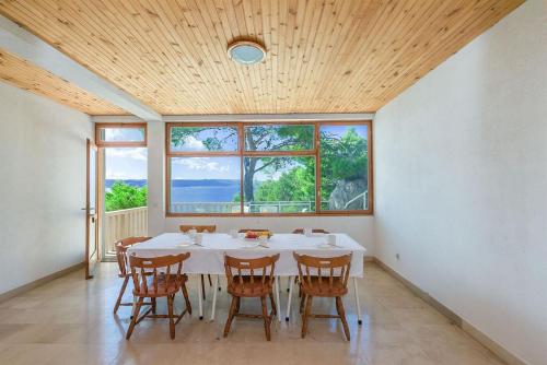 una sala da pranzo con un tavolo e alcune finestre di A Minute to the Sea Brela a Brela