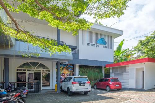 a building with two cars parked in a parking lot at INNCA Telaga Bodas, Semarang in Jatingaleh