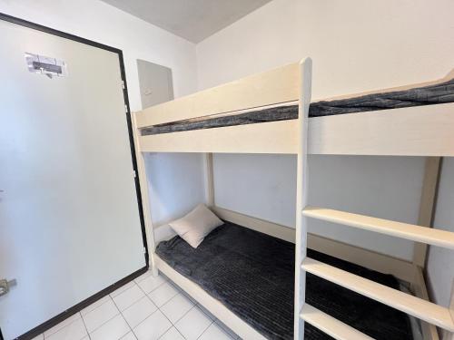 Cette petite chambre comprend des lits superposés et un miroir. dans l'établissement Sol-y-Days Sables d'Or résidence avec piscine, à La Grande Motte