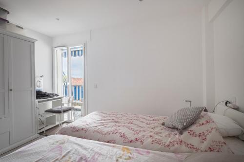 une chambre blanche avec un lit et un bureau dans l'établissement Cros de Cagnes 2 pièces Rev001, à Cagnes-sur-Mer