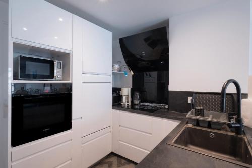 une cuisine avec un évier et un micro-ondes dans l'établissement Cros de Cagnes 2 pièces Rev001, à Cagnes-sur-Mer