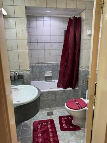 um banheiro com banheira, vaso sanitário e pia em Luxury master room like hotel em Sabkhah