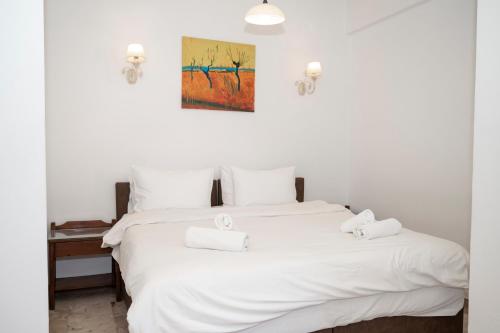 a white bed with two white towels on top of it at Argo Rooms-Papadakis in Kissamos
