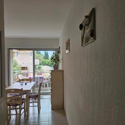 une cuisine et une salle à manger avec une table et des chaises dans l'établissement Studio avec terrasse 2 personnes, au Lavandou