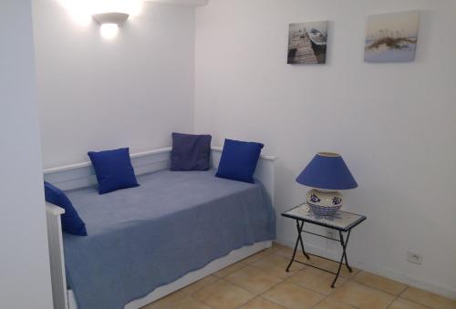 - un lit avec des oreillers bleus et une table avec une lampe dans l'établissement UN BALCON sur LA SAINTE VICTOIRE, à Cadolive