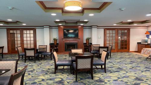 a dining room with tables and chairs and a fireplace at Holiday Inn Express Hotel & Suites Dubois by IHG in DuBois