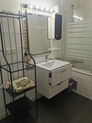 une salle de bain avec un lavabo, un miroir et une chaise dans l'établissement Les coquelicots, à Romainville